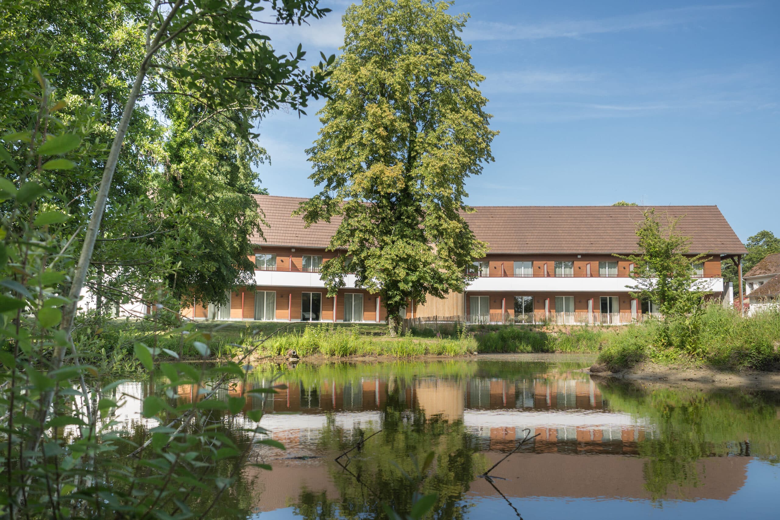 Aménagement textile sur mesure pour hôtel intégrant rideaux et voilages sur mesure en harmonie avec la nature environnante