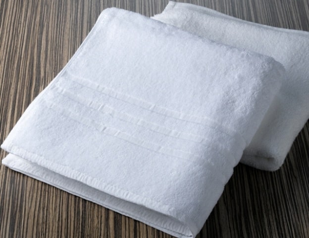 Linge éponge blanc type serviette hôtelière adapté à un usage professionnel intensif