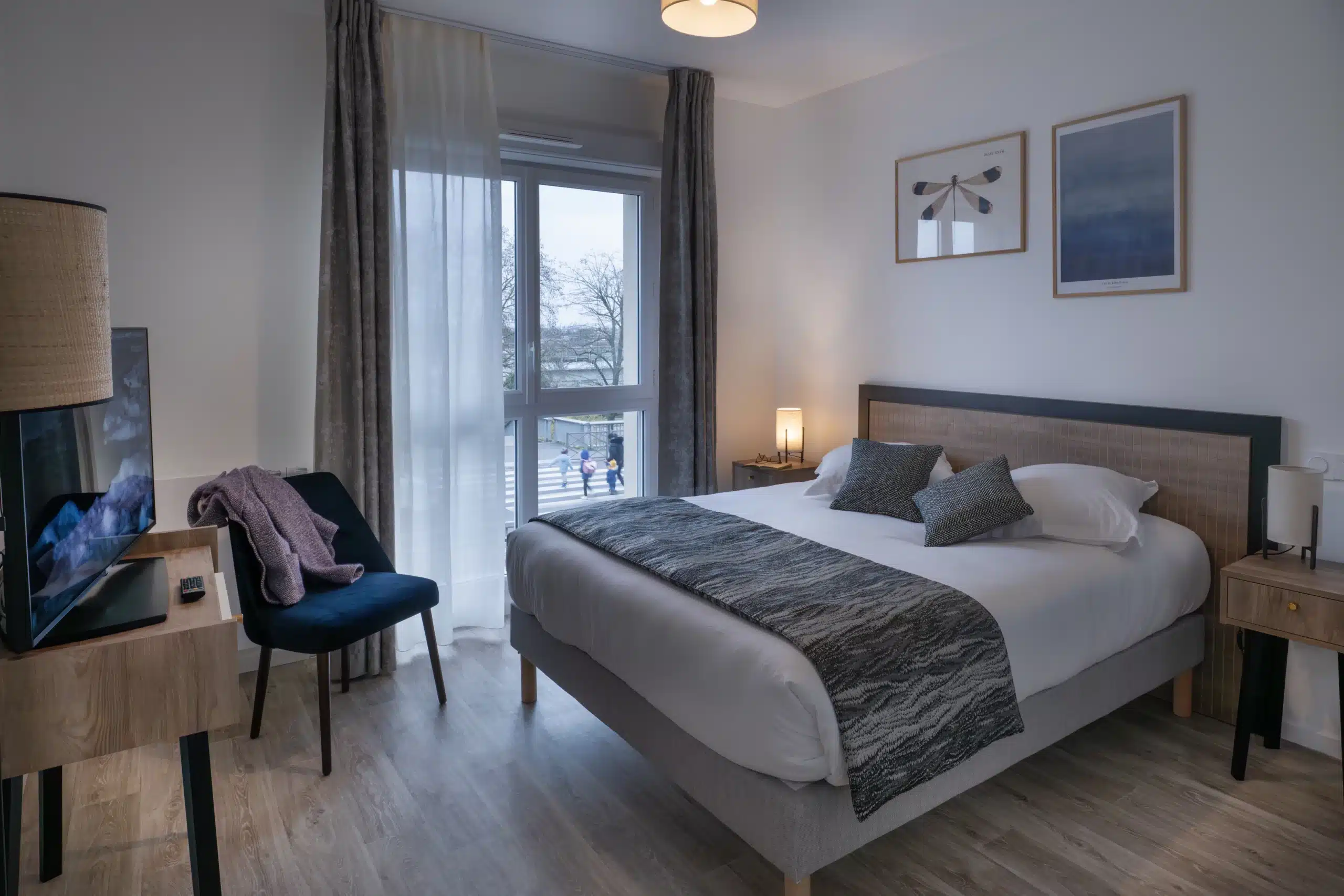 Chambre de résidence senior équipée d'un chemin de lit et de rideaux sur mesure