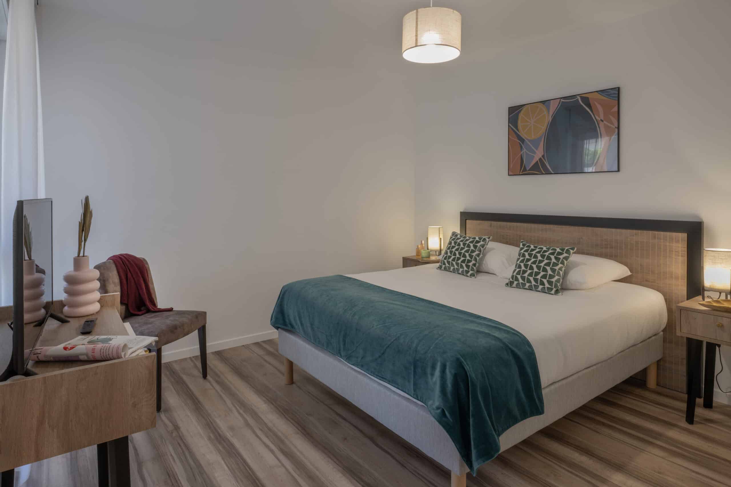Chambre de résidence senior à Aix-en-Provence avec chemin de lit sur mesure bleu et voilage